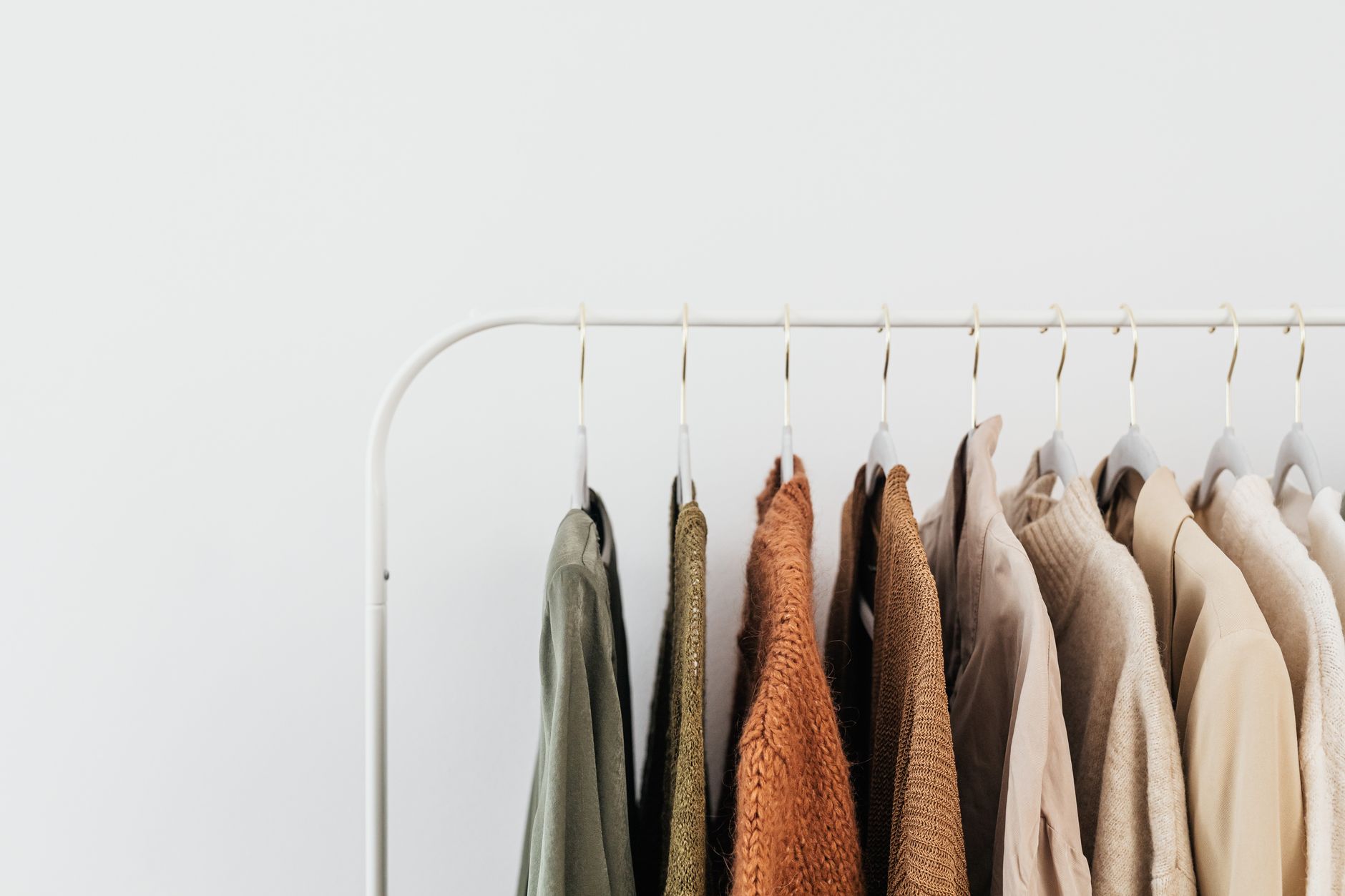 Muted cortisol dressing palette on a wardrobe rail, soft tonal fabric choices