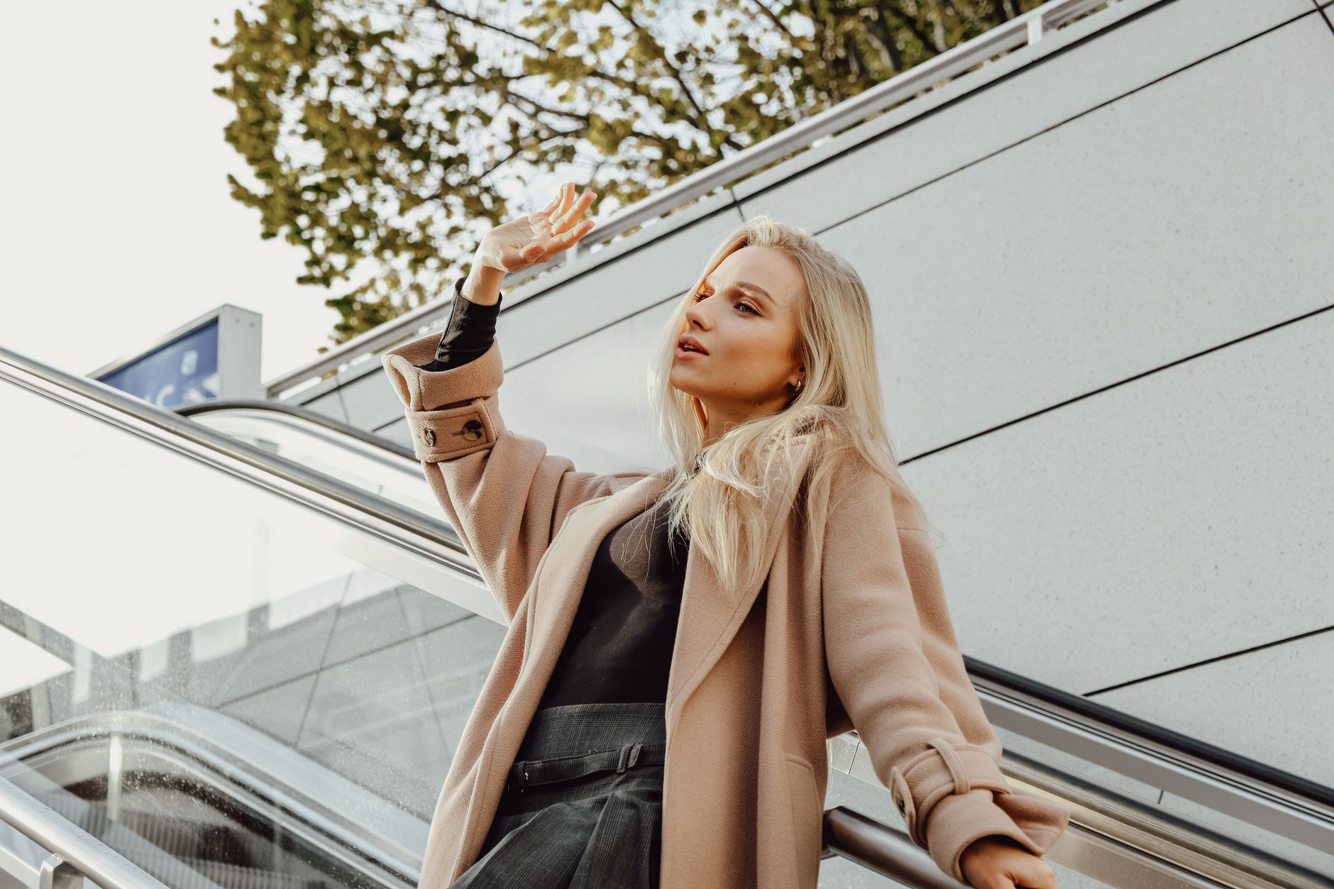 Woman in camel overcoat embodying British quiet luxury investment dressing on a London street